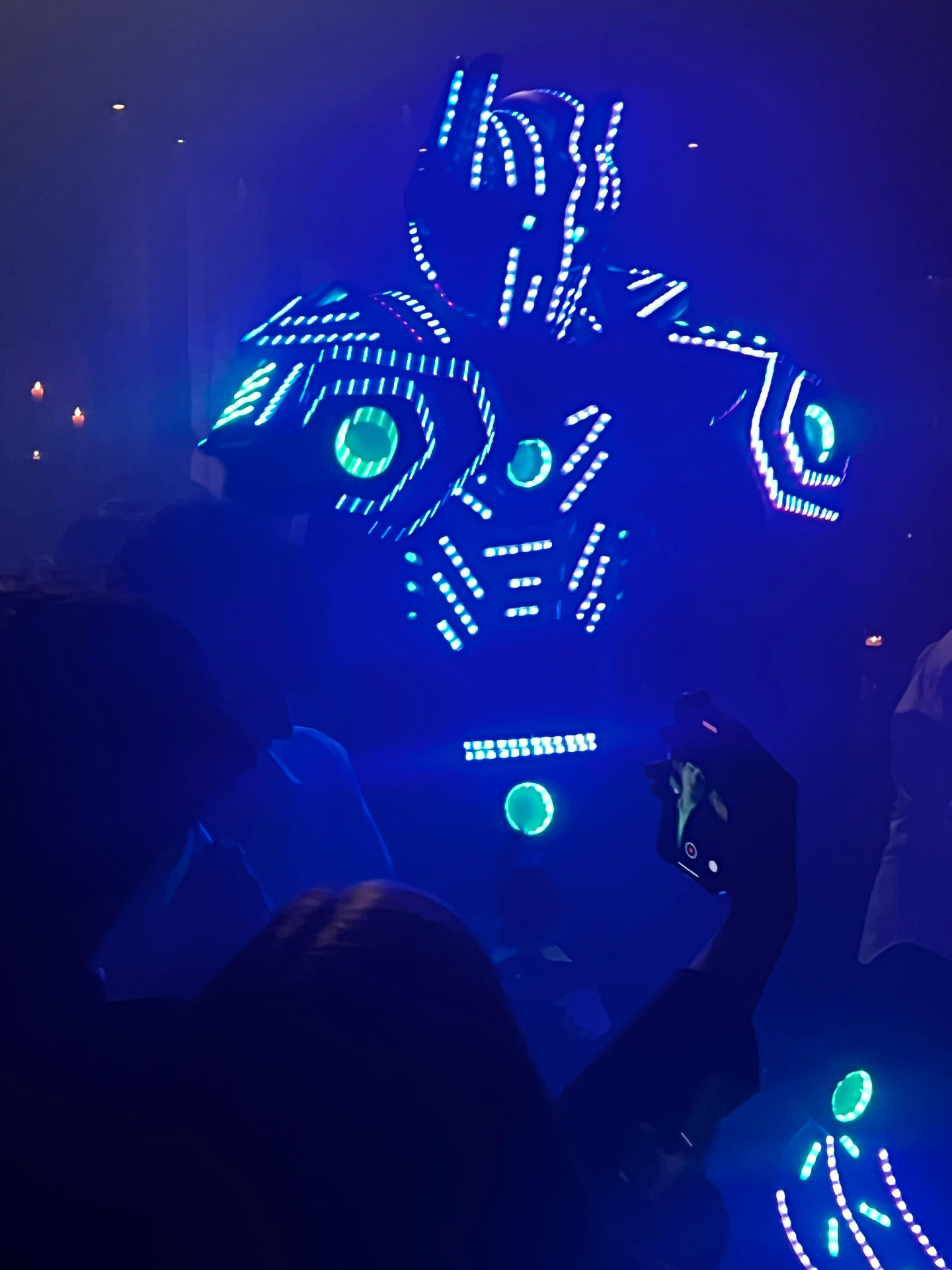 Robô de LED iluminado em balada com público