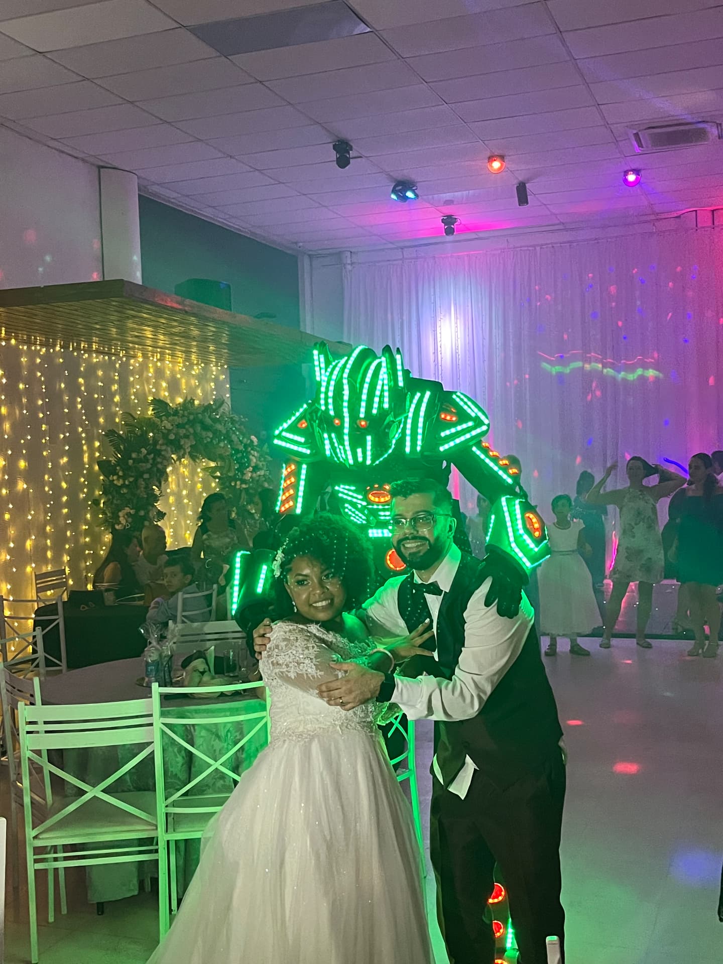 Robô de LED abraçando os noivos na pista de um casamento