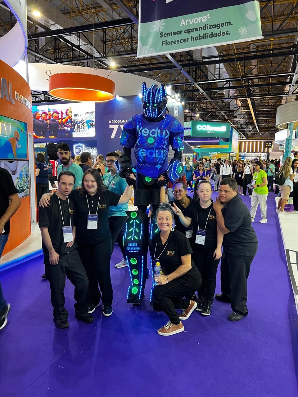 Robô de LED posando com equipe em evento corporativo