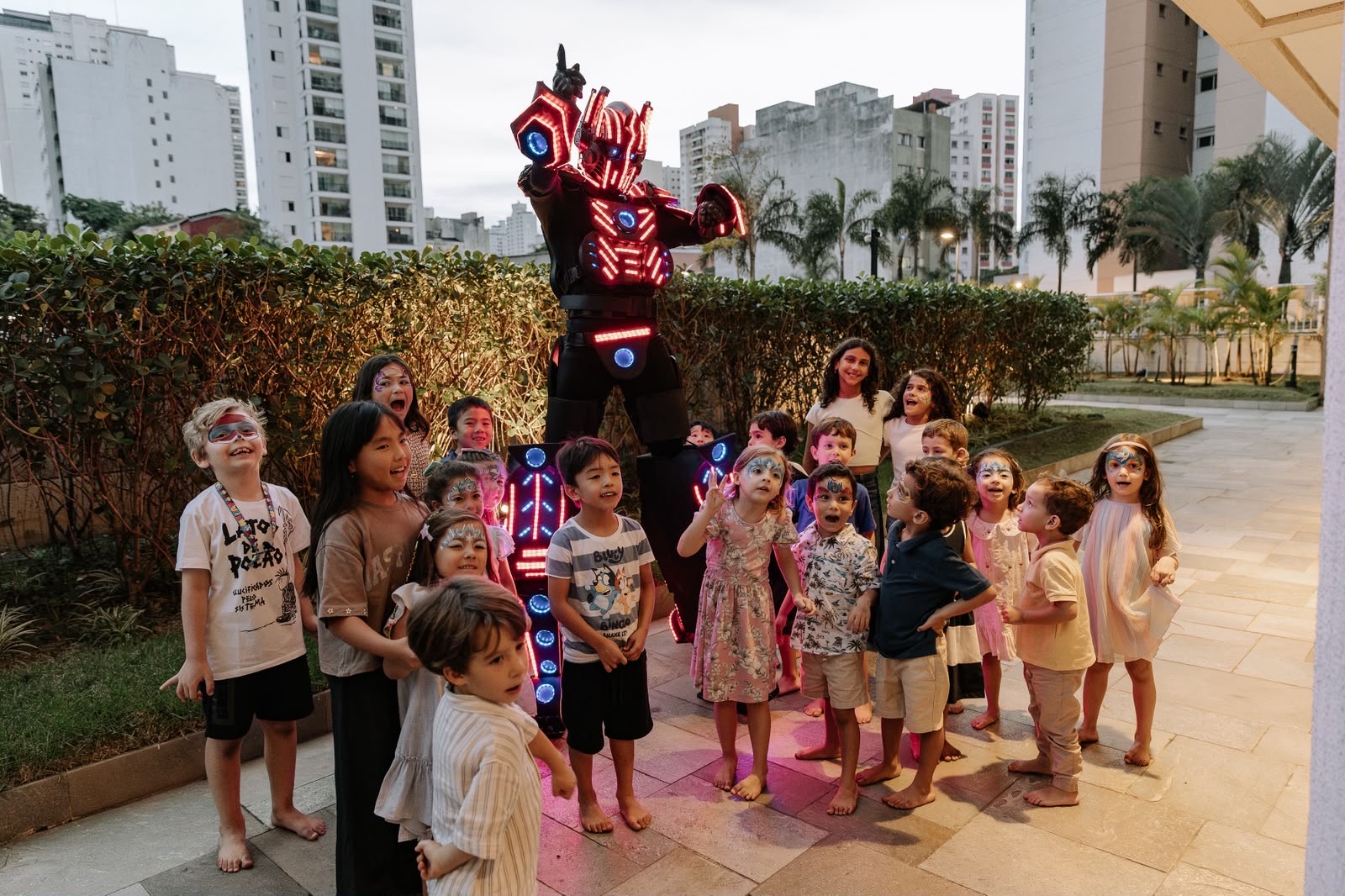Robô de LED cercado por crianças em festa ao ar livre
